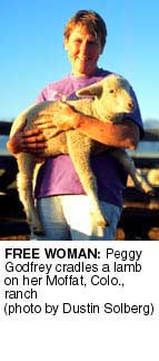 Peggy Godfrey cradles a lamb on her Moffat, Colo.,
ranch