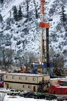A drill rig looms over the man camp