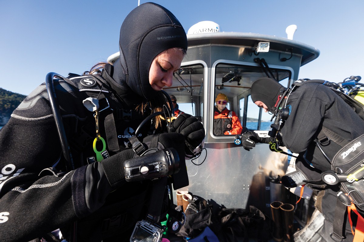 Jennie De La Cruz and Charlie Donahue prepare to make a dive during an October trip to replace a data collection sensor in the water.